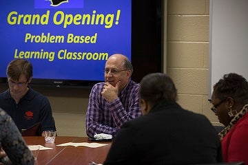 Group of people sitting around a table in the Problem Based Learning Classroom
